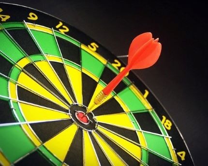 A dart in the bullseye of a dartboard.